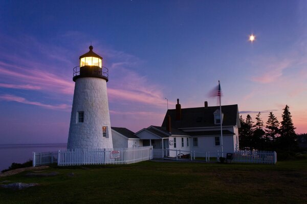 Weißer Leuchtturm in lila Sonnenuntergang