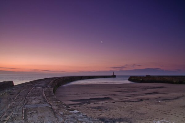 Pier going from the shore to the sea in the evening light