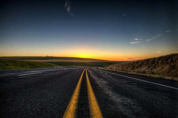 Strada con segnaletica che va al tramonto