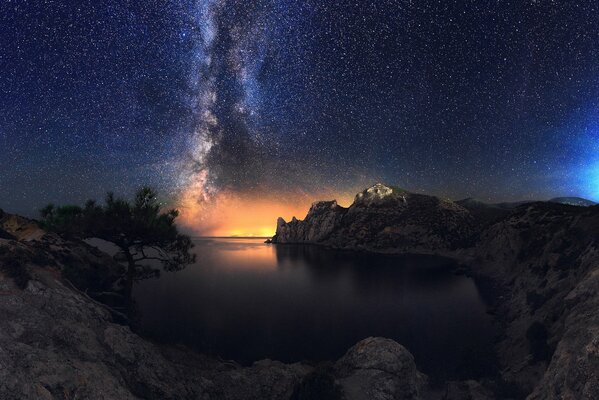 Ночная красота звёздного неба моря каменистого берега
