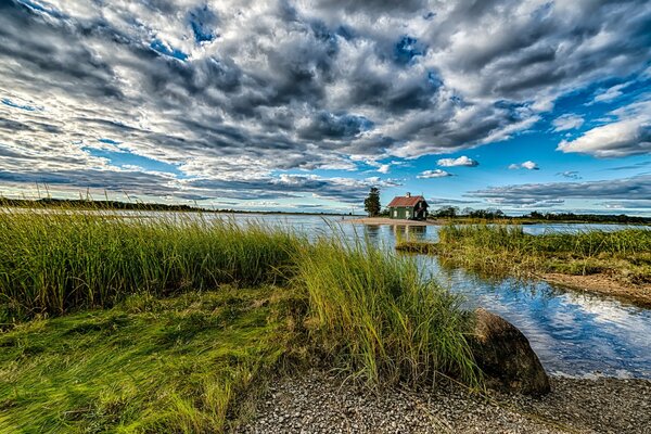 Haus am Wasser vor dem Hintergrund der Wolken