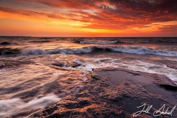 Photo avec un extrait de la mer agitée au coucher du soleil