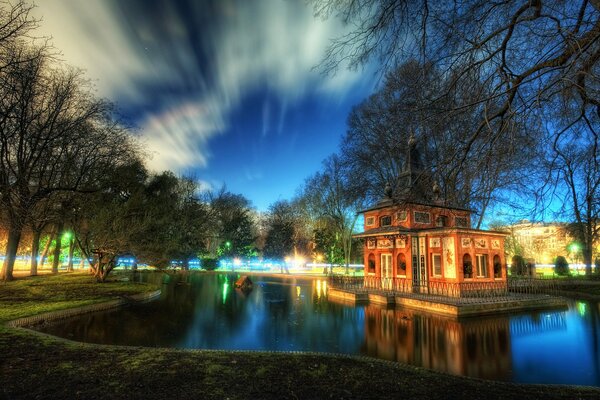 Ein Haus im Park am Teich mit schönen Wolken