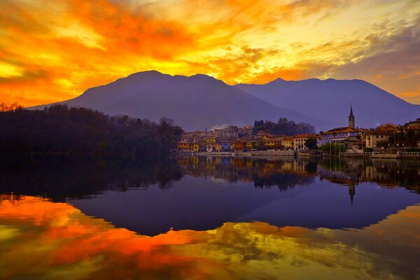 Reflection of the evening city in the rays of sunset