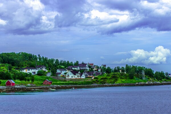 Collines norvégiennes avec de petites maisons sur fond de baie