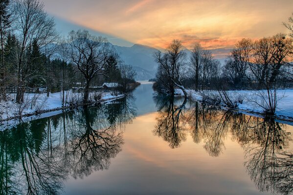 The winter river reflects the glow of the sky