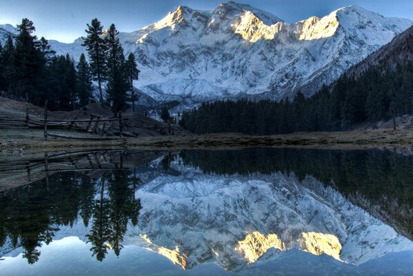 Snowy mountains are reflected in the water