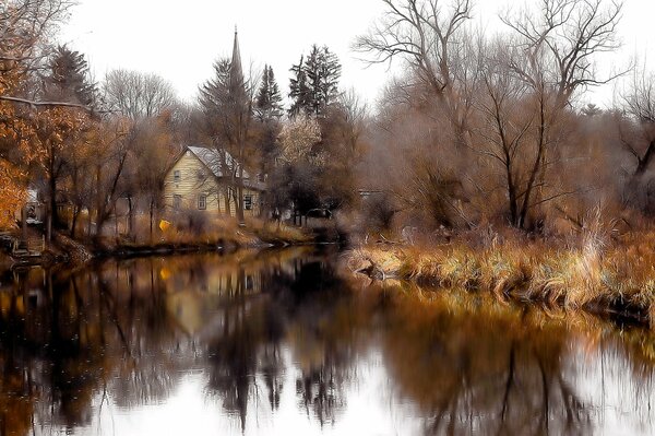 Casa de dos pisos junto al lago en el bosque en otoño