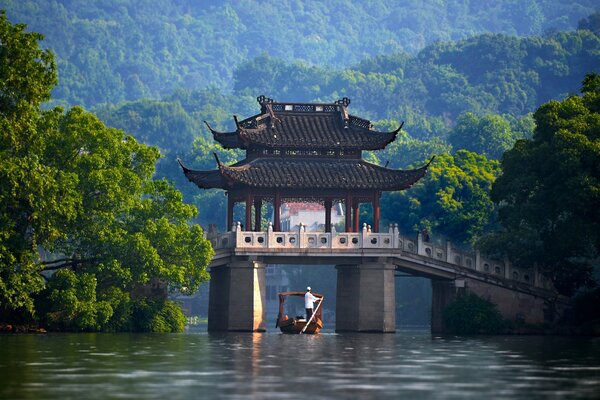 Chinese bridge in the middle of the river against the background of trees
