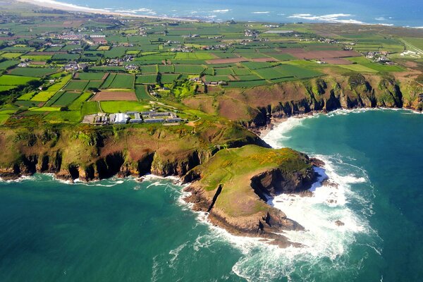 View of the cultivated fields with hilly shores and the emerald-blue sea