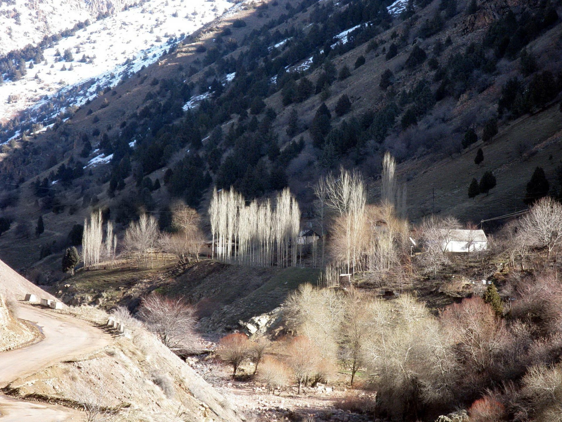 mountain snow sun glare river channel house