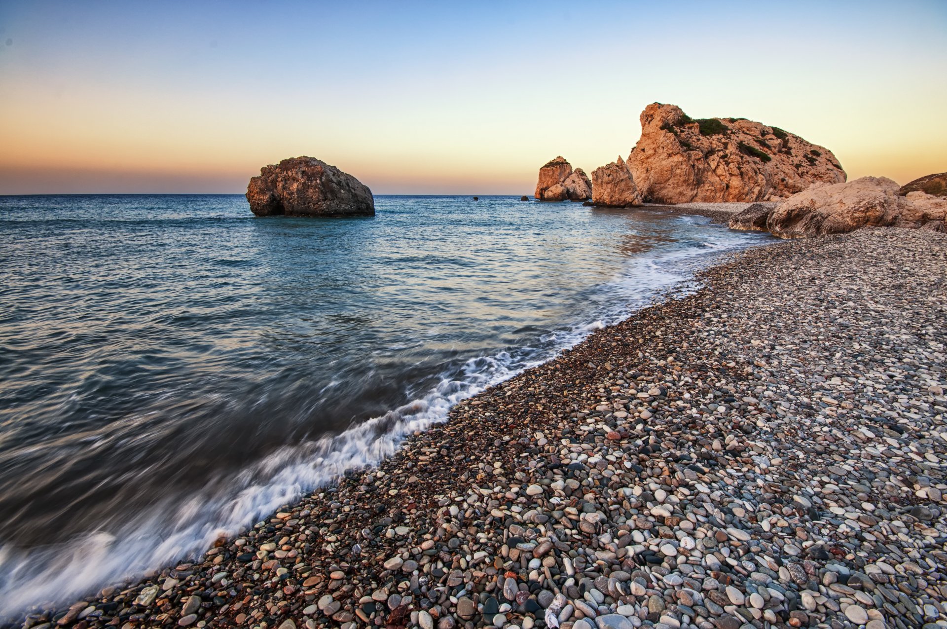 paesaggio mare ciottoli spiaggia rocce tramonto