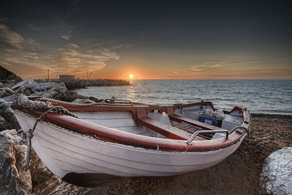 Barca sulla riva al tramonto