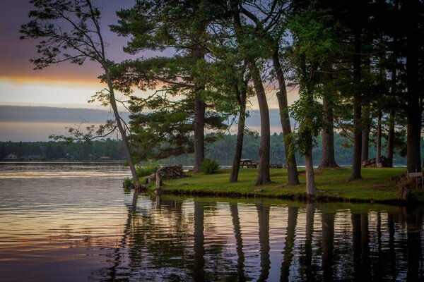 Lago con alberi sulla riva con il riflesso del cielo