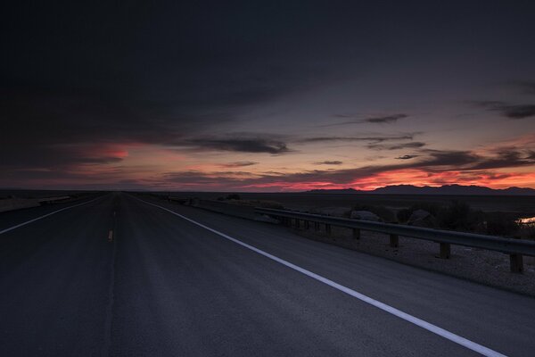 Route sur fond de coucher de soleil écarlate