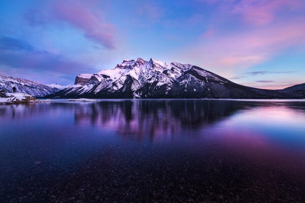 Montagne enneigée au-dessus du lac mauve