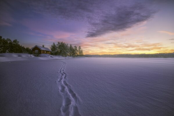 Winterlandschaft mit Haus. Spuren im Schnee