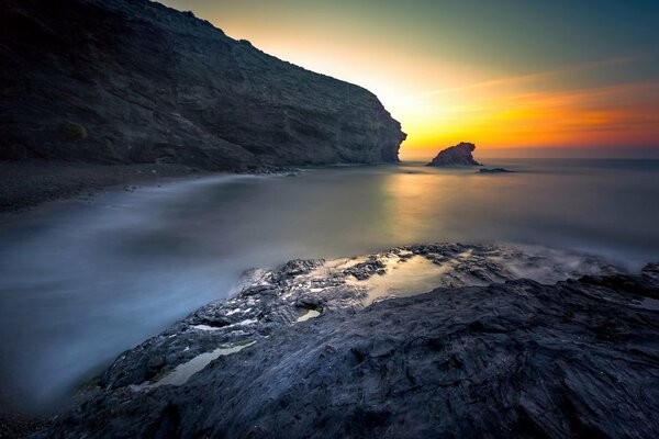 Zachód słońca nad morzem i skałami