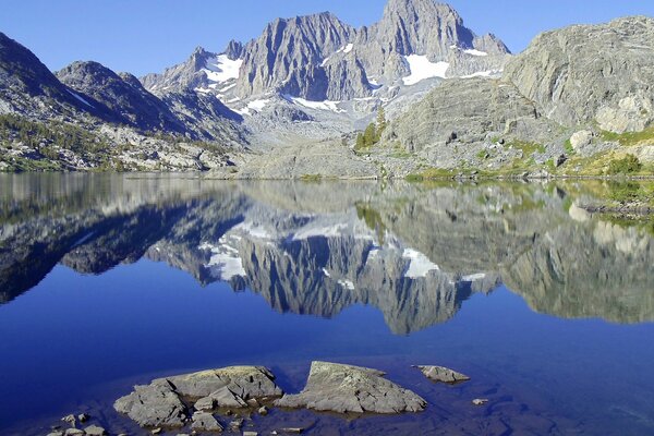 Montagnes enneigées se reflètent dans le lac