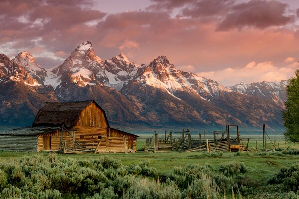 Barn on the background of the sunset rocky mountains