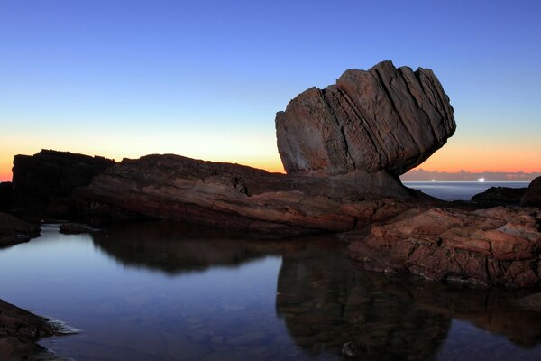 Reflet des rochers dans la mer au coucher du soleil