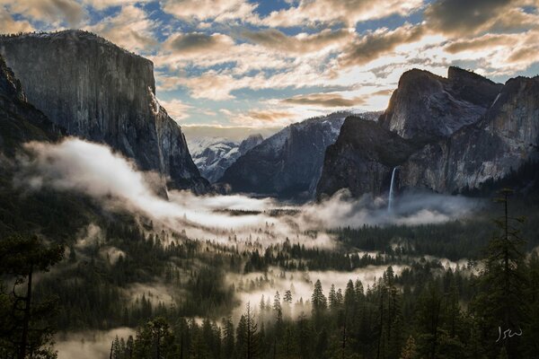 A valley shrouded in fog among mountain peaks