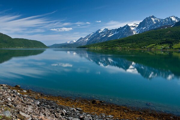 Blauer Himmel und Berge spiegeln sich im See wider