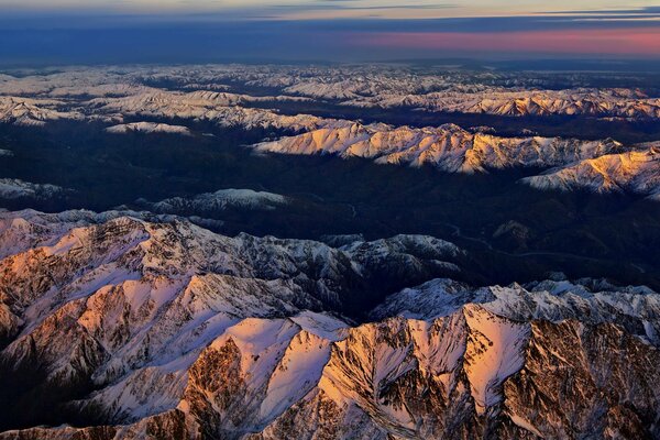 Cime innevate delle montagne al tramonto