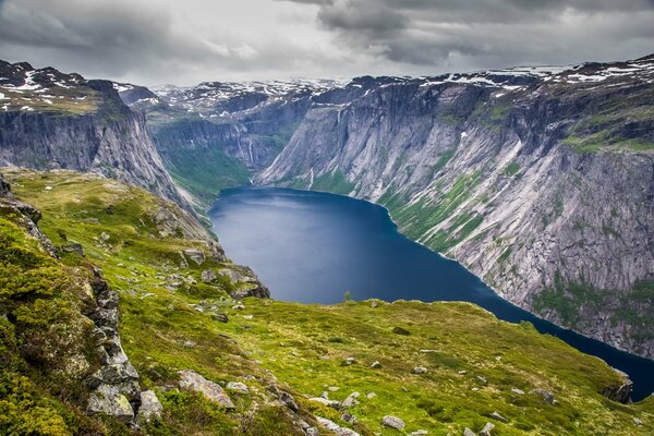 A lake in the middle of the mountains under a gray sky