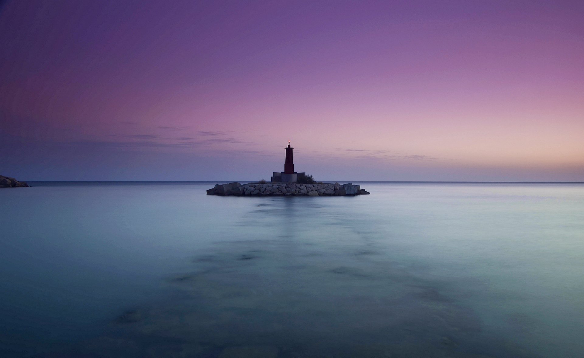 mar océano calma faro noche lila cielo