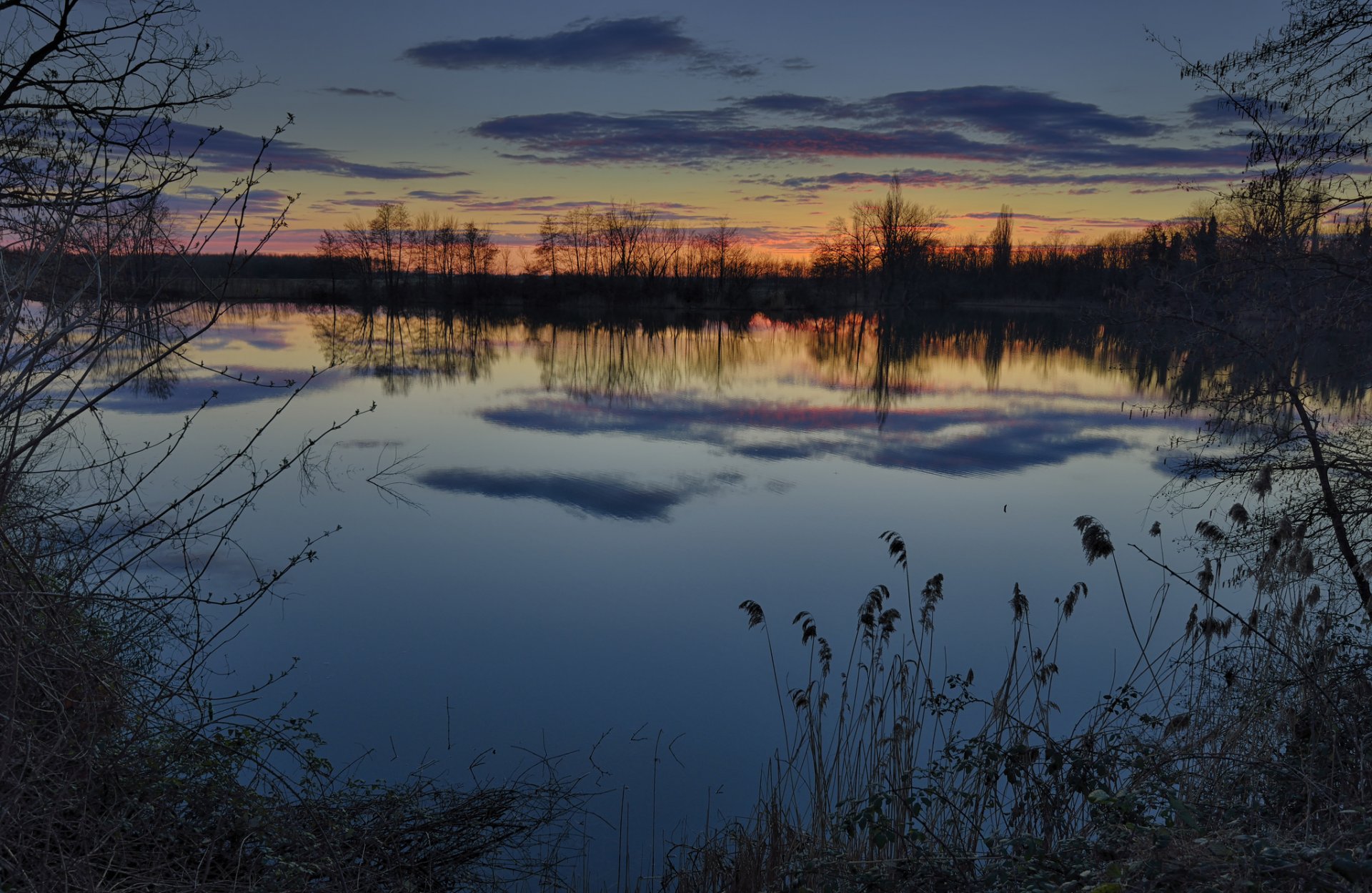 abend winter sonnenuntergang fluss wasser ufer gras bäume himmel wolken reflexion