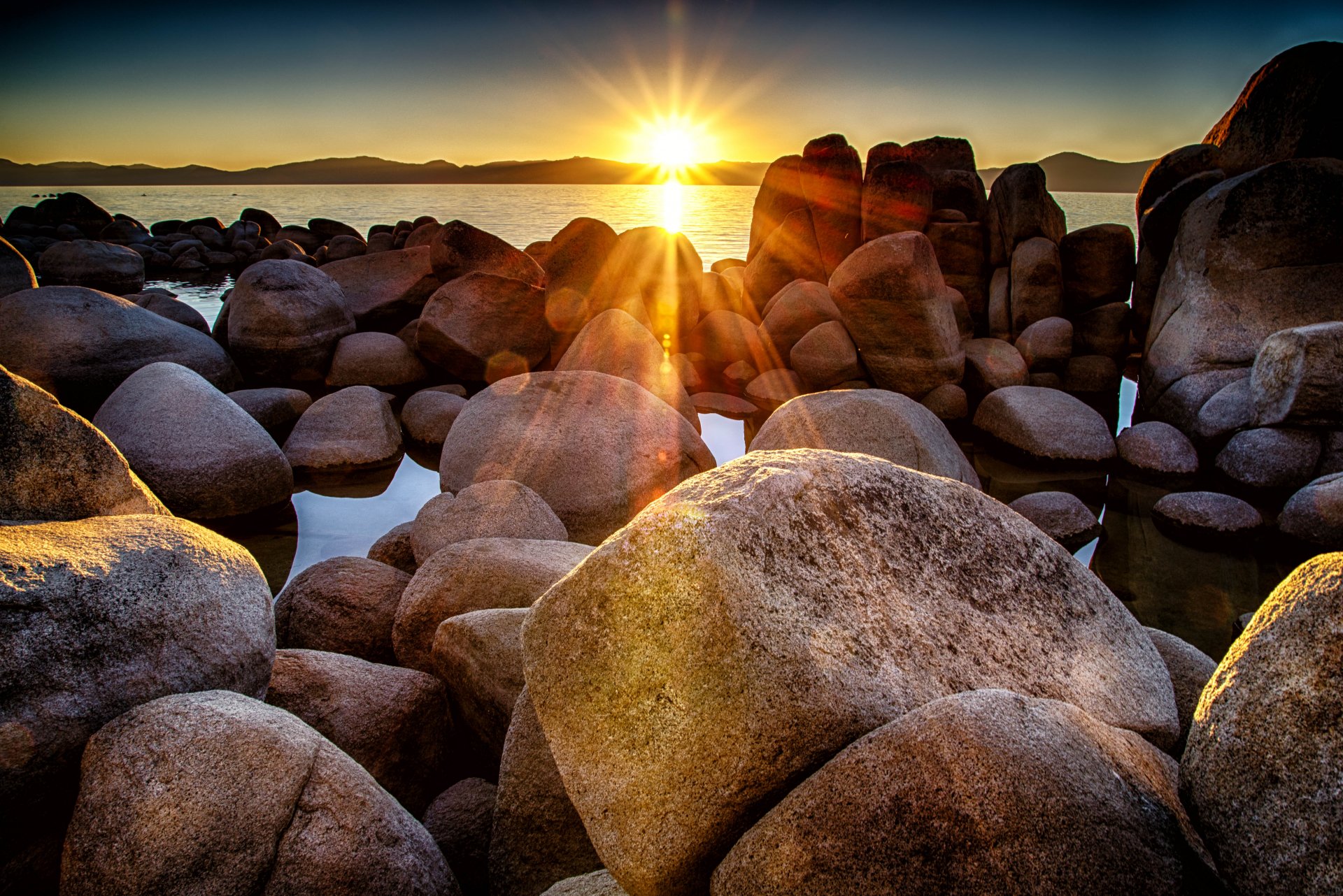 bucht ufer steine felsbrocken sonne sonnenuntergang