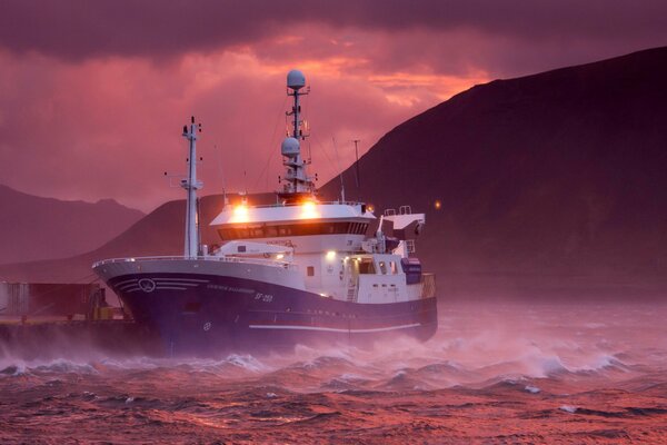 Un barco navega a través de una tormenta al amanecer