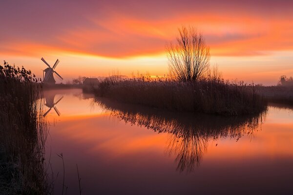 Lever du soleil sur fond de lac et moulin