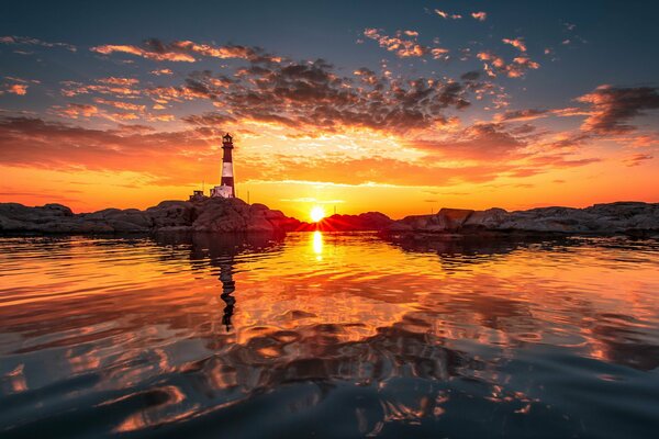 Orange sunset over the sea and lighthouse