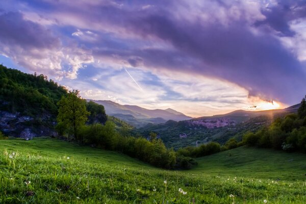 Puesta de sol en la ladera verde de la montaña