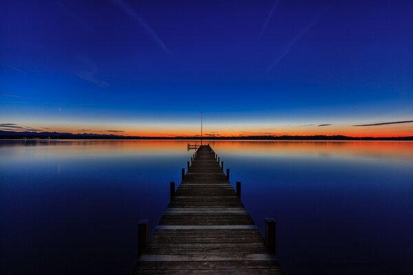 Puesta de sol en el lago Starnberg en el muelle en Baviera