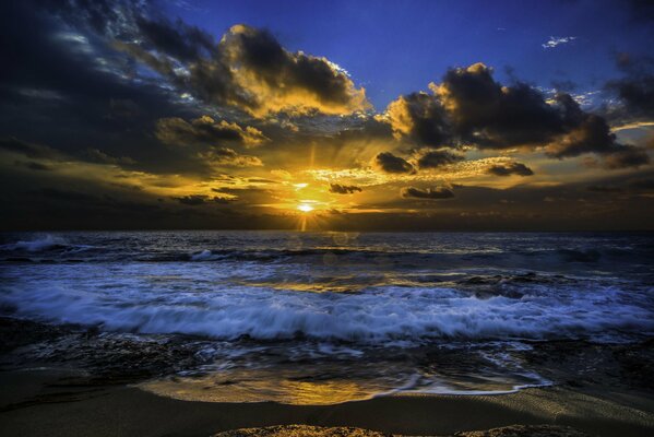 The sun breaks through the clouds over the ocean