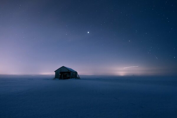 Ein einsames Haus steht in einem schneebedeckten Feld