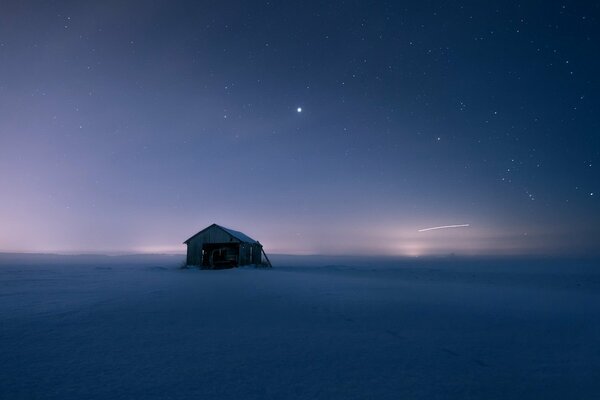 Maison solitaire debout dans un champ de neige