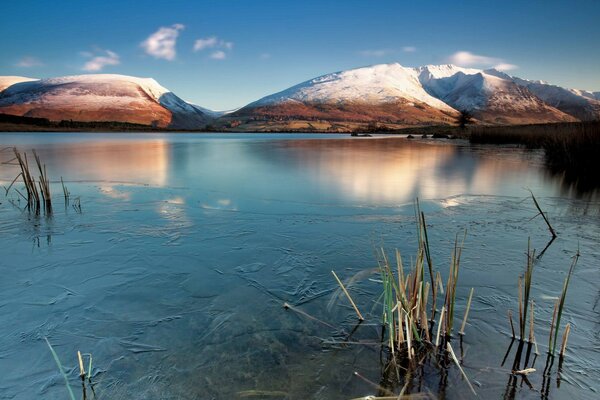 Lago limpido tra le montagne innevate