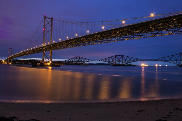 Pont avec éclairage sur la rivière de nuit