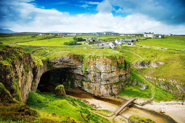 Paesaggio colorato della Scozia. Si affaccia su piccole case e montagne.. Verde brillante