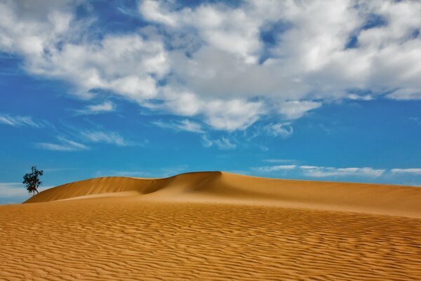 Immagine con sabbia e nuvole blu