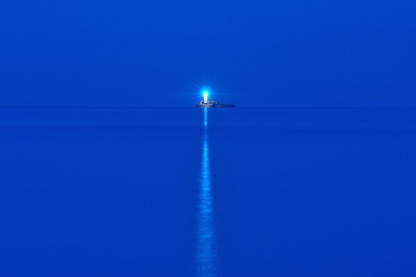 Mer bleue dans la nuit. Phare de l île