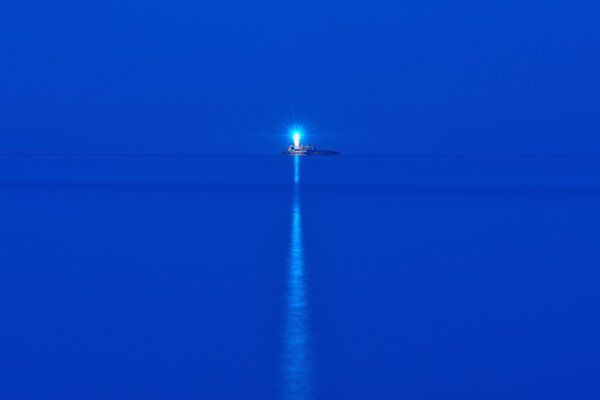 Błękitne morze w nocy. Latarnia morska na wyspie