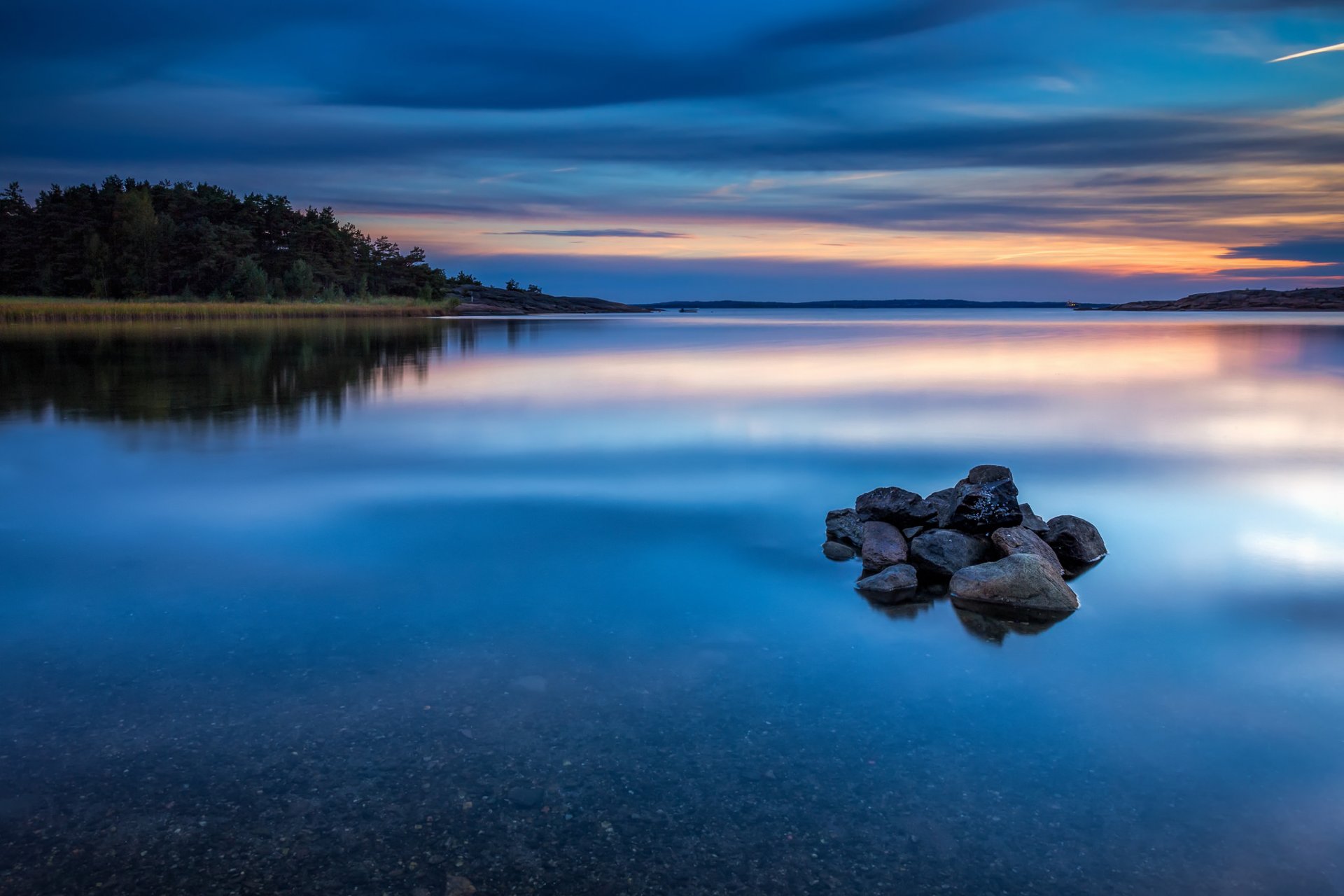 norvegia fiume acqua superficie liscia riva rocce foresta alberi sera tramonto cielo blu nuvole riflessione natura