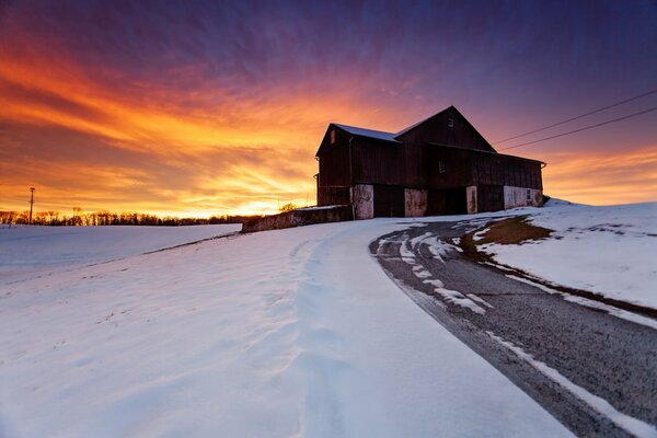 Winter landscape house on the background of sunset