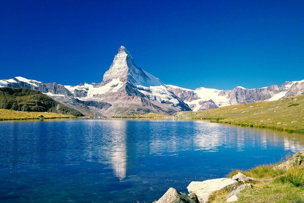 Picos de primavera de las montañas junto al lago