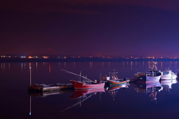 Barche rosse nel porto notturno